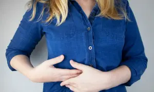 Persona con dolor costilla flotante derecha, se lleva las manos al abdomen.