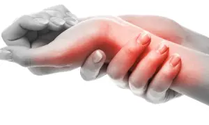 Manos con área roja en la muñeca, indicando dolor. El **sinovitis tratamiento fisioterapia** puede aliviar esta inflamación.