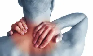 Hombre con dolor de cuello y hombros, sintiendo los síntomas de cervicales.