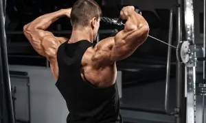 Hombre musculoso entrenando el deltoides posterior con polea.