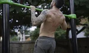 Hombre realizando dominadas, mostrando la fuerza de sus bíceps y espalda. Los músculos implicados en las dominadas son clave para este ejercicio.