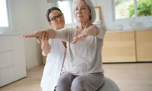 Fisioterapeuta ayuda a una mujer mayor a mejorar su equilibrio y fuerza, trabajando en diferentes niveles de Berg.
