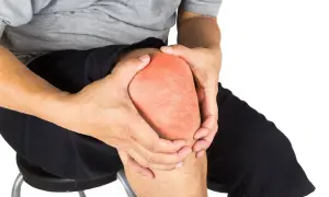 Hombre con dolor en la rodilla, con la rótula enrojecida. A pesar del dolor, se puede andar con la rótula rota.