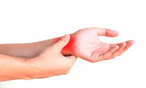 Una mano se presiona la muñeca, con una zona roja indicando dolor. ¿Cómo saber si tengo la muñeca abierta?