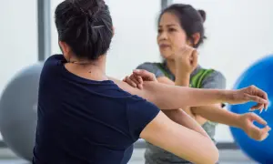 Dos mujeres estiran sus brazos, enfocándose en el músculo braquial bíceps.