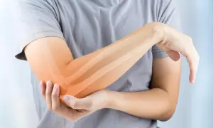 Persona con dolor en el codo, resaltando los ligamentos del codo con un tono naranja.