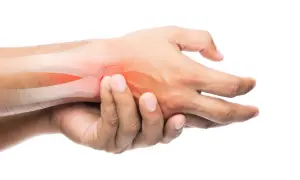 Mano con hueso resaltado en rojo, indicando posible fractura de dedo. El tiempo de recuperación es clave.