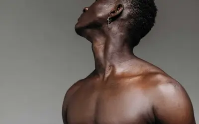 El músculo esternocleidomastoideo se define en el cuello de un hombre, con un pendiente de cruz.