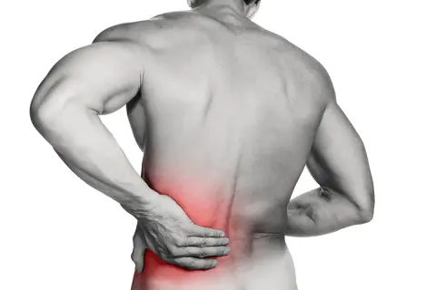 Hombre con mano en la espalda baja, zona roja indica dolor lumbar.