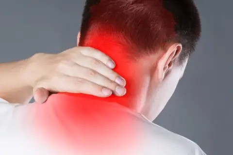 Hombre con dolor en la nuca, zona roja indica posible neuralgia occipital. Busca ejercicios para aliviar la tensión.