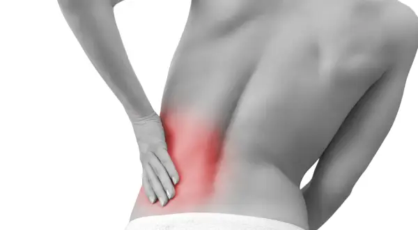 Persona con dolor lumbar izquierdo, con la mano apoyada en la zona afectada, resaltada en rojo.