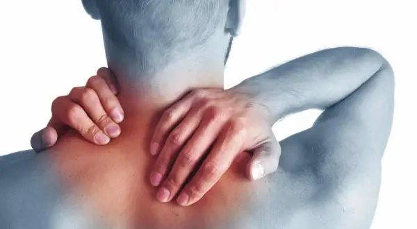 Hombre con dolor de cuello y hombros, sintiendo los síntomas de cervicales.