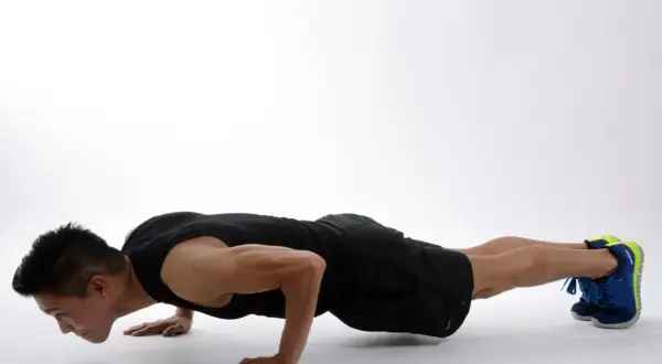 Hombre haciendo flexiones, un ejercicio efectivo para fortalecer los ejercicios triceps y el pecho.