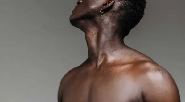 El músculo esternocleidomastoideo se define en el cuello de un hombre, con un pendiente de cruz.