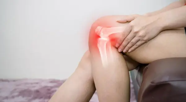 Rodilla con radiografía que muestra condropatía rotuliana grado 4, con dolor marcado en rojo.