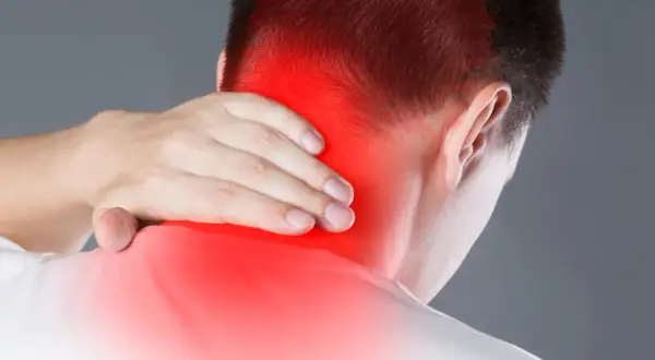 Hombre con dolor en la nuca, zona roja indica posible neuralgia occipital. Busca ejercicios para aliviar la tensión.