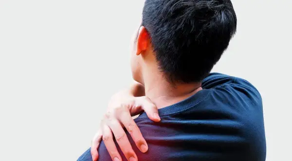 Hombre con dolor desde el hombro hasta los dedos, tocando su hombro izquierdo con la mano.