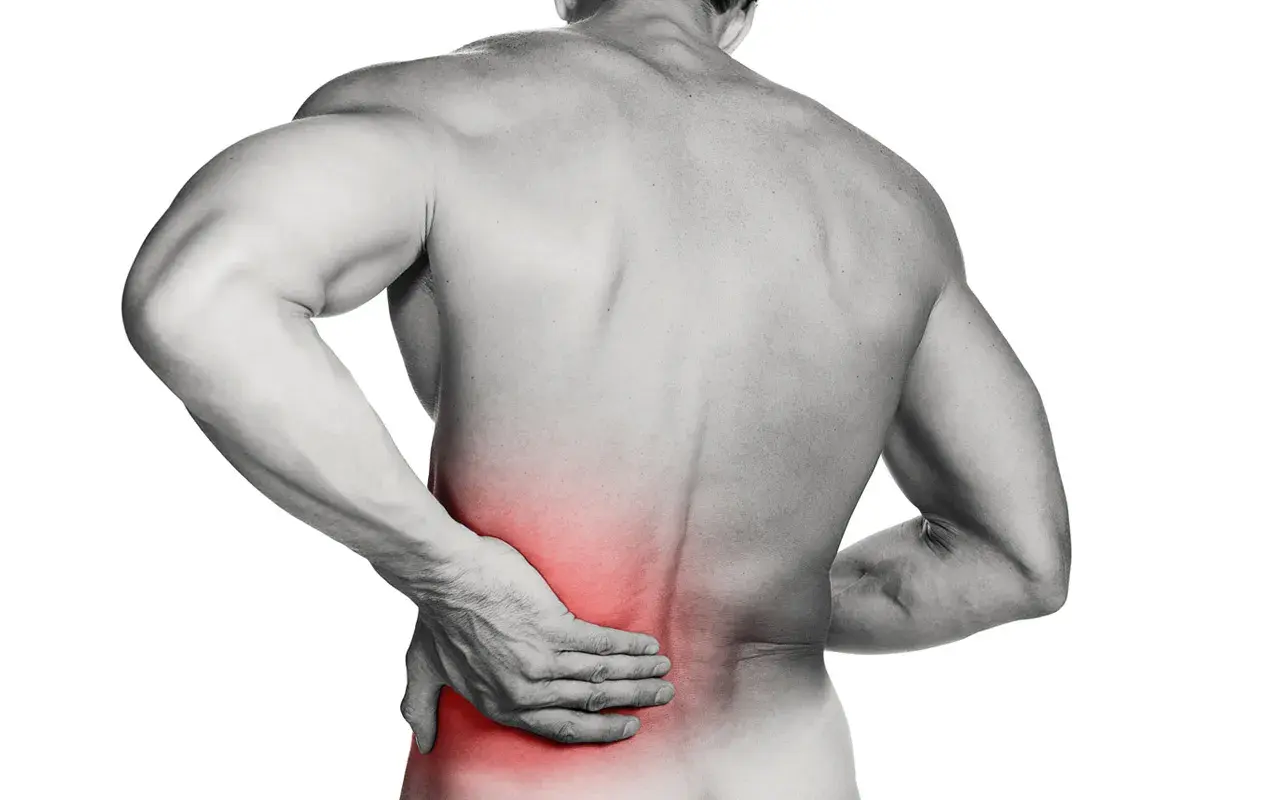 Hombre con mano en la espalda baja, zona roja indica dolor lumbar.