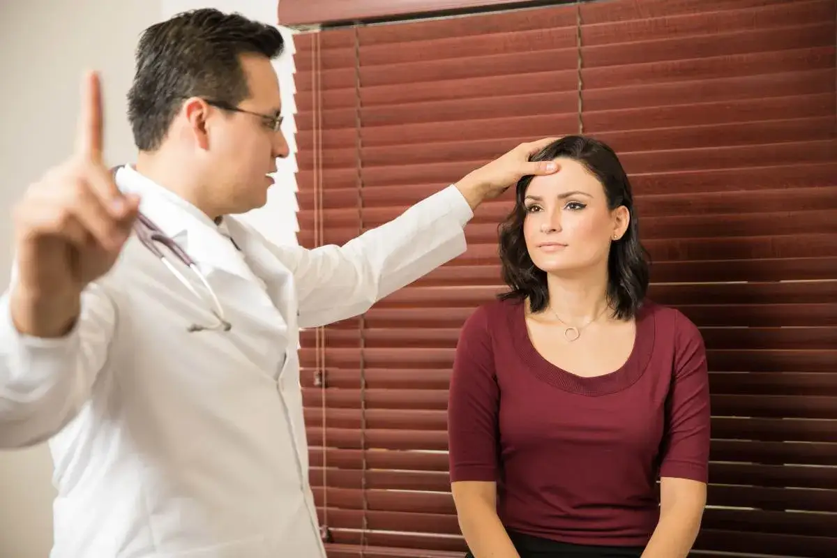 Médico realiza test Romberg a una paciente, evaluando su equilibrio y coordinación neurológica.