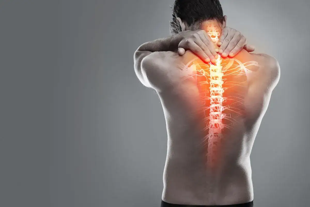 Hombre con dolor de espalda, resaltando las vertebras dorsales con un brillo rojizo que indica inflamación o molestia.