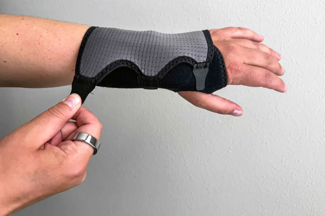 Persona ajustando una muñequera para aliviar el dolor en la muñeca al apoyar la mano.