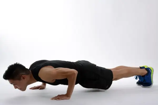 Hombre haciendo flexiones, un ejercicio efectivo para fortalecer los ejercicios triceps y el pecho.