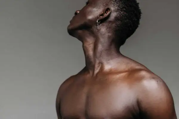 El músculo esternocleidomastoideo se define en el cuello de un hombre, con un pendiente de cruz.